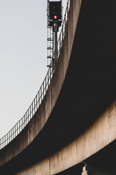 Looking up towards a concrete elevated railway track and signal.  Belfast, Northern Ireland.