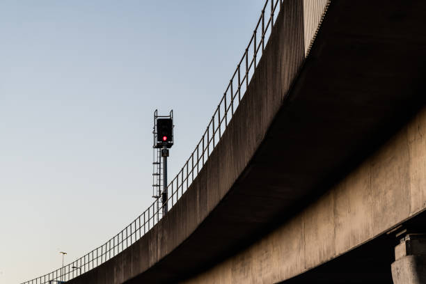 Looking up towards a concrete elevated railway track and signal.  Belfast, Northern Ireland.