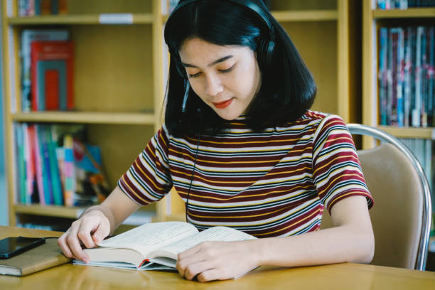 istock Young university student reading book in university library. Female university student reading book prepare for final examination. Teenager reading book in free time. Education and life style concept. 1175401614