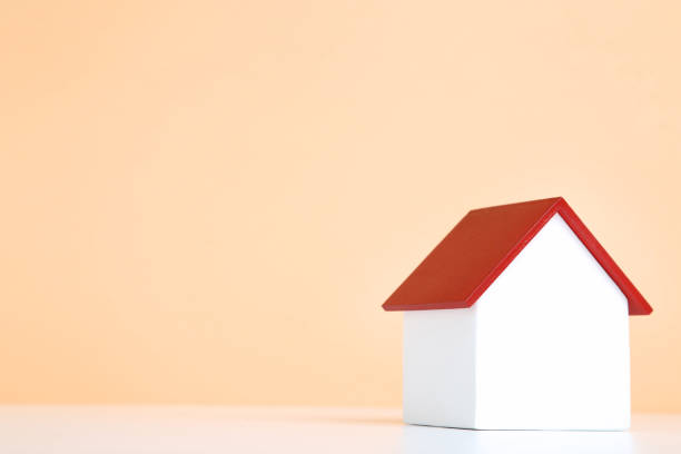 istock Wooden house model on beige background 1175404565