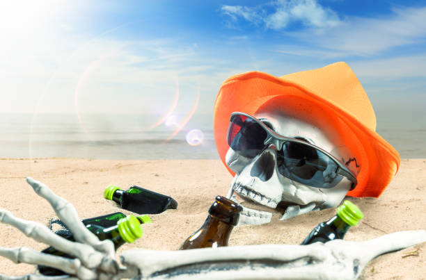 skeleton of a celebrating person died of too much alcohol on a beach - alcoholism narcotic excess alcohol imagens e fotografias de stock