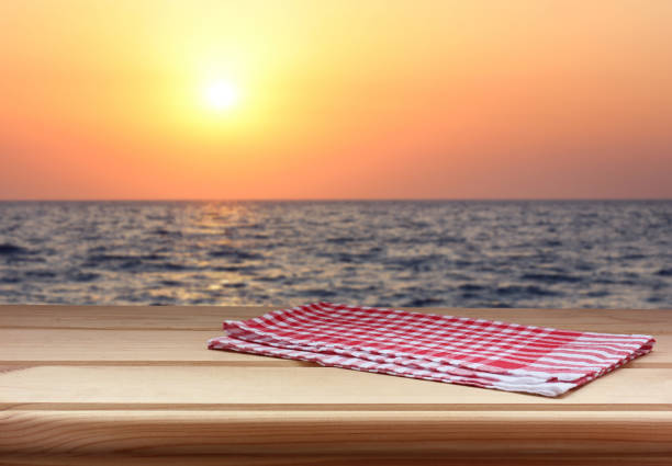 istock empty table with a red towel against the sunset on the sea. 1175404679