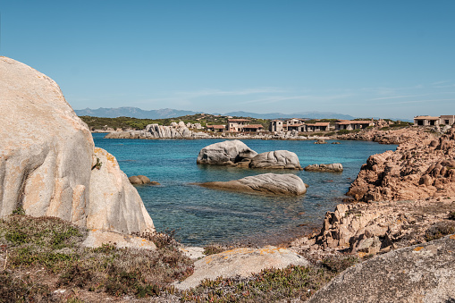 Large granite boulders and abandoned fisherman's village on the coast of Cavallo Island n the Lavezzi archipelago of Corsica