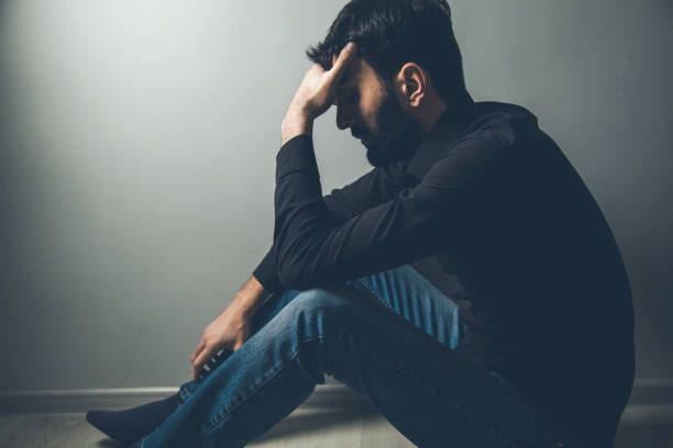 istock sad man hand in head sitting ground 1175405396