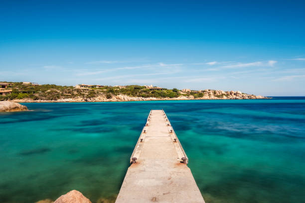 Long exposure image of an old jetty over a turquoise mediterranean sea on the coast of Cavallo Island n the Lavezzi archipelago of Corsica
