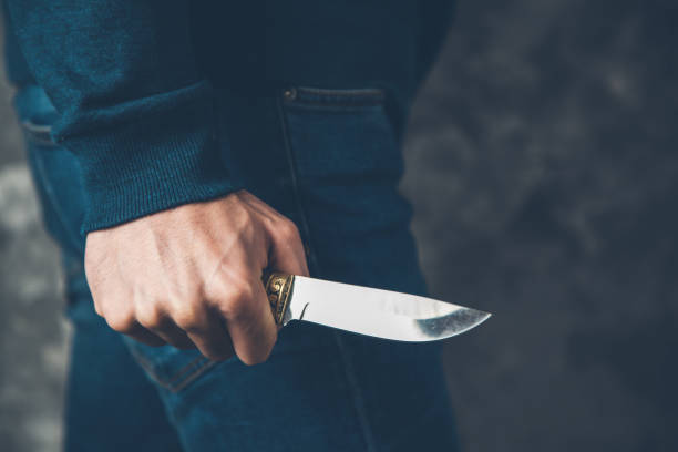 uomo mano tenendo coltello su sfondo astratto - blade foto e immagini stock