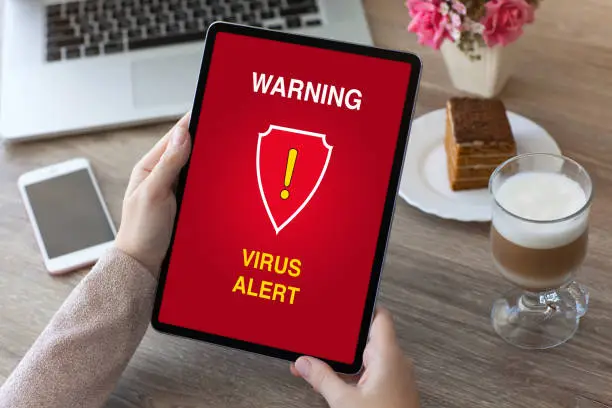 Photo of woman hands holding tablet computer with warning virus alert alarm