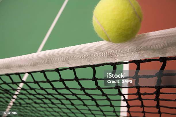 Bola Saltando Sobre La Red De Una Cancha De Tenis Bajo Techo Foto de stock y más banco de imágenes de Amarillo - Color