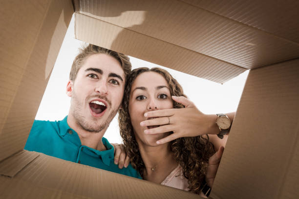 Couple opening cardboard box very happy stock photo