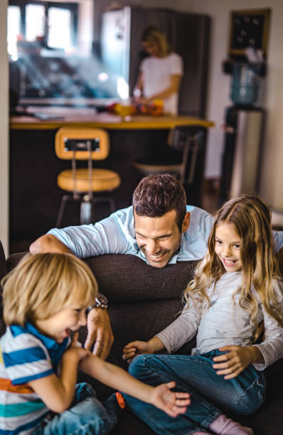 istock Happy father having fun with his small kids at home. 1175415400