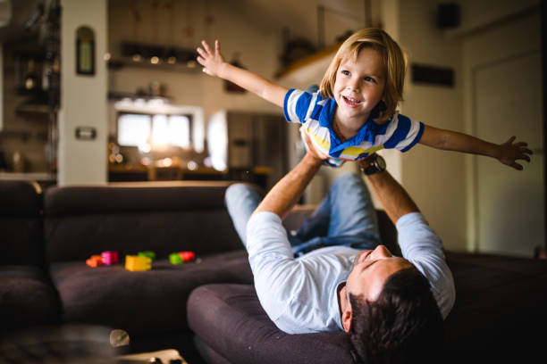 istock Happy boy having fun while playing with his father at home. 1175415437
