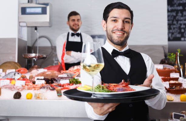 istock Waiter with serving tray in fish restaurant 1175416556