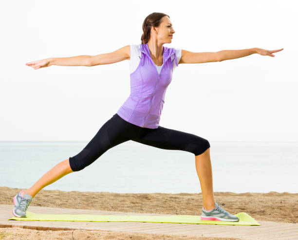 istock Woman practising yoga poses standing on beach 1175418762