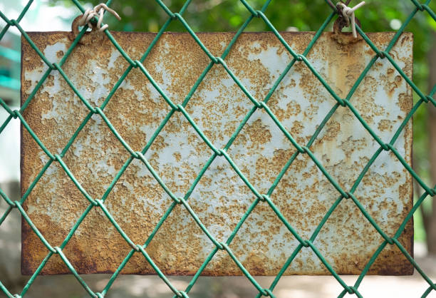 istock The old metal plaque that decayed behind the green mesh cage in the park. 1175420455