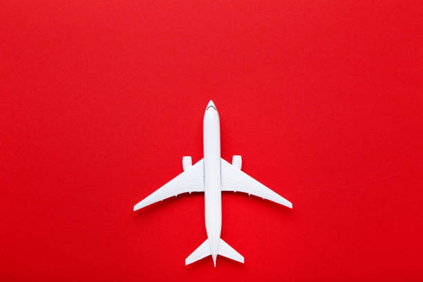 istock Airplane model on red paper background 1175420696