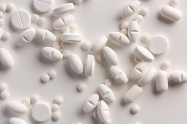 White pills on white background. Flat lay. stock photo