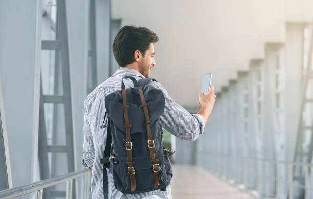 istock Tourist using his cellphone in airport, connecting to roaming 1175423476