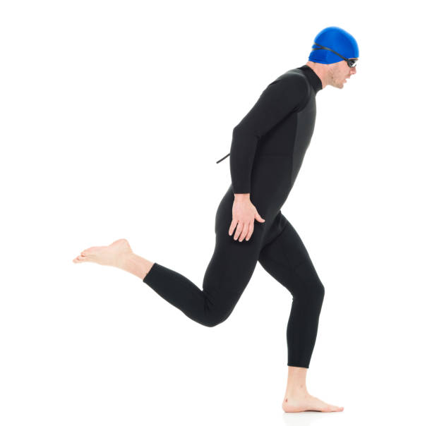 full length / one man only / one person / side view / profile view of 30-39 years old handsome people caucasian male / mid adult men / mid adult triathlete doing triathlon / swimming / running / exercising in front of white background - swimming male isolated swimming goggles imagens e fotografias de stock