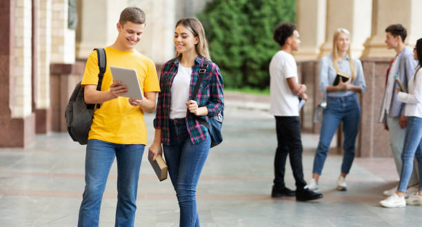 istock Classmates preparing for lecture with digital tablet outdoors 1175424202