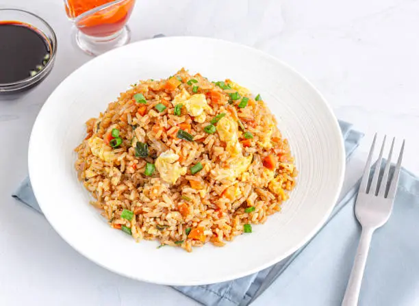 Asian Chinese Fried Rice with Vegetable and Eggs Served with Ketchup and Soy Sauce.