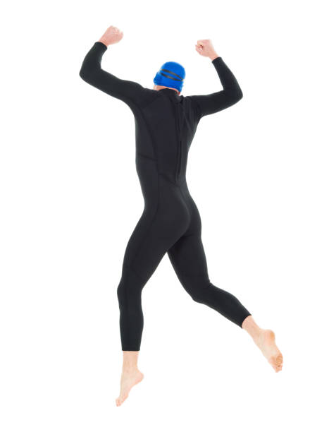 full length / one man only / one person / rear view of 30-39 years old handsome people caucasian male / mid adult men / mid adult triathlete doing triathlon / swimming / jumping / mid-air in front of white background who is joy / excited - swimming male isolated swimming goggles imagens e fotografias de stock