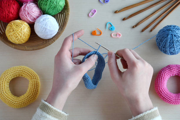 istock Making crochet pyramid from colored rings. Toy for babies and toddlers to learn mechanical skills and colors. On the table threads, needles, hook, cotton yarn. Handmade crafts. DIY concept. 1175425568
