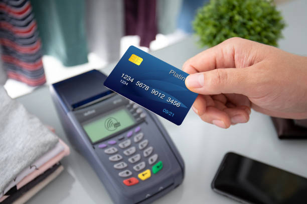 istock Man hand holding plastic card and pay pass online terminal 1175425775