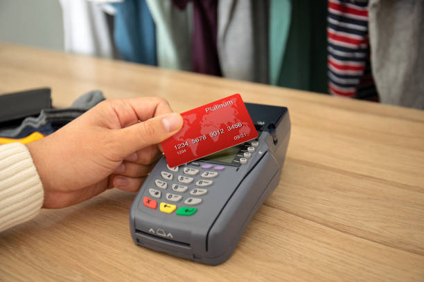istock Man hand holding plastic card and pay pass online terminal 1175425817