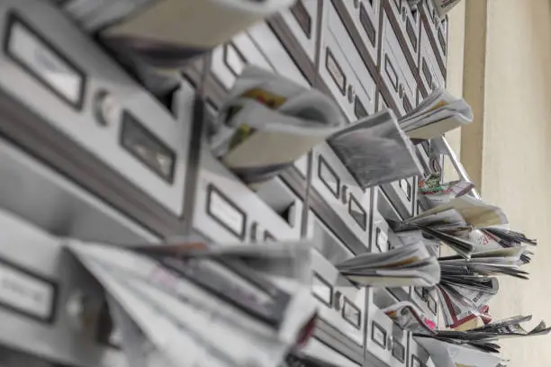 Modern metal mail boxes, overfull of leaflets. Ideal for concepts.