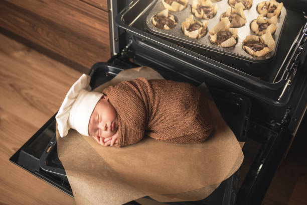 neugeborenes baby trägt kochmütze liegt auf dem ofen tablett mit einem muffins - dreams baby lying on back child stock-fotos und bilder