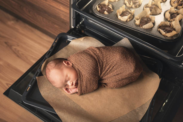 neugeborenes baby liegt mit einem muffin auf dem ofentablett - dreams baby lying on back child stock-fotos und bilder