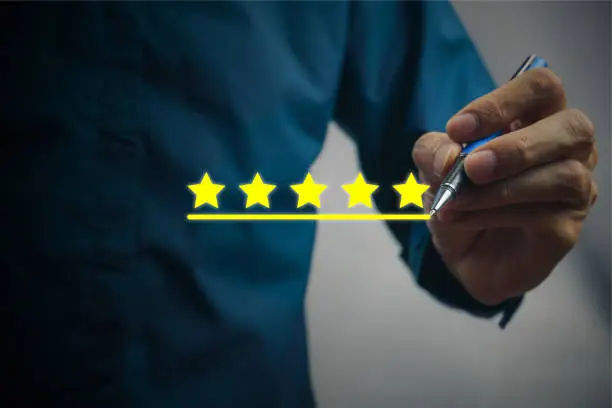 Photo of Conceptual the customer responded to the survey. The client using digital pen write five stars icon. Depicts that customer is very satisfied. Service experience and satisfaction concept.
