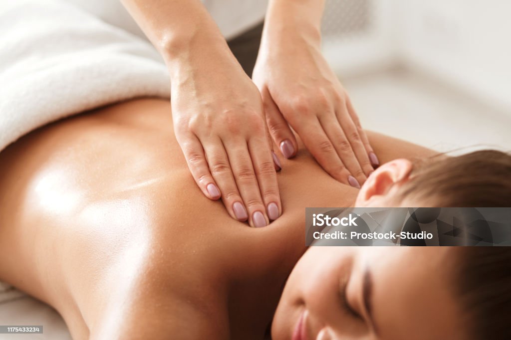 Jonge vrouw genieten van therapeutische nekmassage in Spa - Royalty-free Masseren Stockfoto Jonge vrouw genieten van therapeutische nekmassage in Spa - Royalty-free Masseren Stockfoto