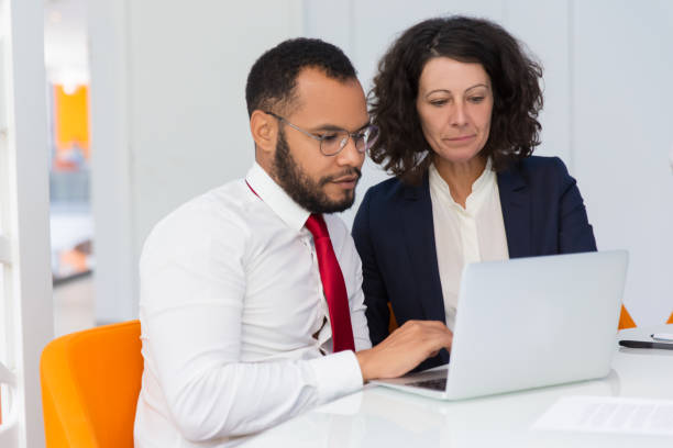 istock Serious business colleagues working on laptop together 1175434095
