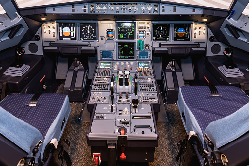 Cockpit of airliner. Switches and dials visible in the background. Interior big airplane.