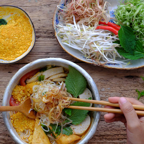 people eating Vietnamese vegan rieu noodle soup or vegetarian crab paste vermicelli soup