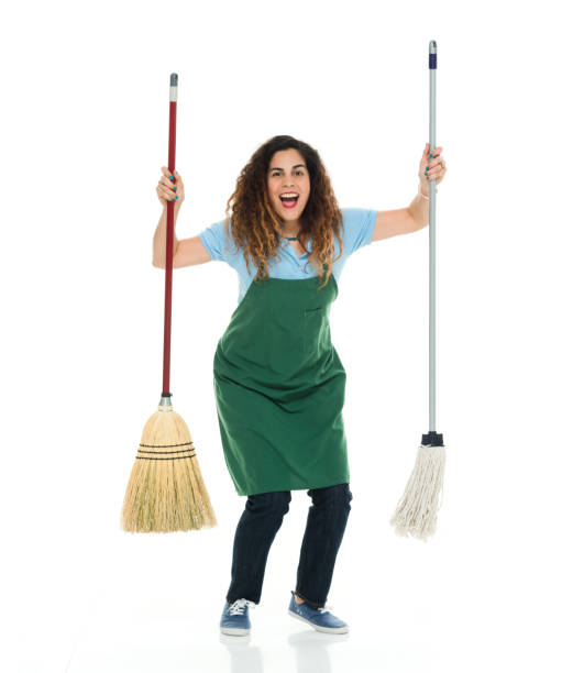 Full length / one person of 30-39 years old adult beautiful puerto rican ethnicity / latin american and hispanic ethnicity female / young women / one young woman only barista / with part-time job / caretaker / cleaner / manual worker standing in front of white background wearing jeans / apron / t-shirt / shirt / canvas shoe who is smiling / happy / cheerful / cool attitude who is working / sweeping / cleaning / doing chores and holding broom / using mop / hygiene longitud completa / una persona de 30-39 años de edad adulto hermoso etnia puertorican / latín americano y hispano etnia femenina / mujeres jóvenes / una mujer joven sólo barista / con trabajo a tiempo parcial / cuidador / limpiador / trabajador manual