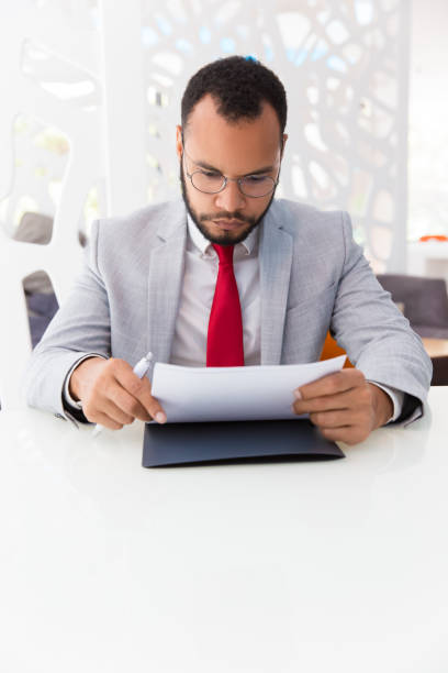 istock Focused business leader reading agreement text 1175446523