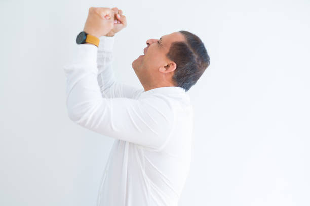 istock Middle age man celebrating and screaming happy for successful win 1175447518