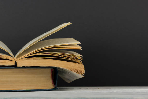 istock Open book, hardback books on wooden table. Back to school. Copy space 1175447653