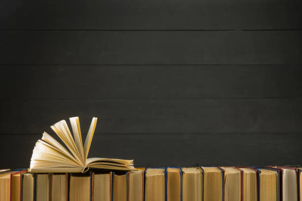 istock Open book, hardback books on wooden table. Back to school. Copy space 1175448097