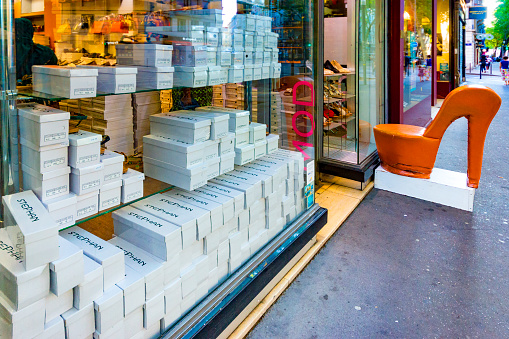 Shoe store display in a store window in Lyon, France with a giant size high heel shoe next to the doorway.