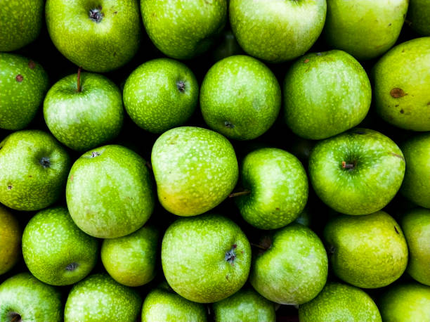 Background of green apples in the market. Ripe fruits on the counter. stock photo