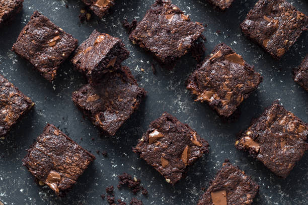 istock Baked chocolate brownie squares on mottled grey background texture - selective focus 1175450642