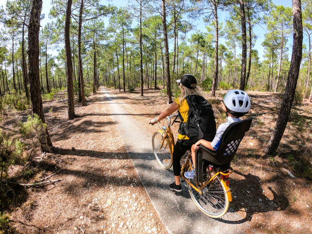 Mother and son cycling through the forest stock photo