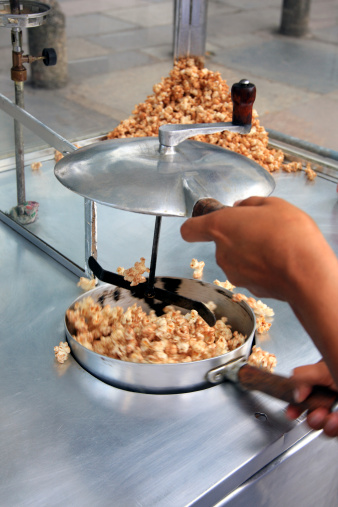 Popcorn pushcart. Preparation of sweet popcorn.