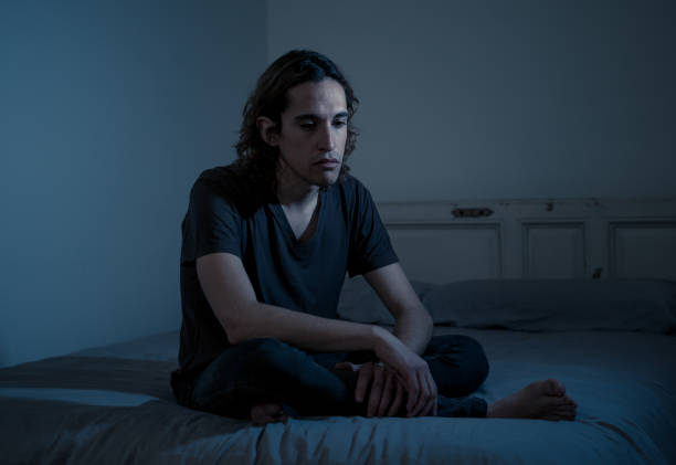 istock Devastated millennial man crying sad feeling hurt and hopeless suffering Depression. Depressed teenager victim of bullying or abuse sitting on bed alone in despair at night. In teenage Mental health. 1175451886