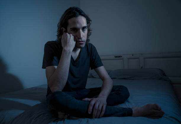 istock Devastated millennial man crying sad feeling hurt and hopeless suffering Depression. Depressed teenager victim of bullying or abuse sitting on bed alone in despair at night. In teenage Mental health. 1175451925