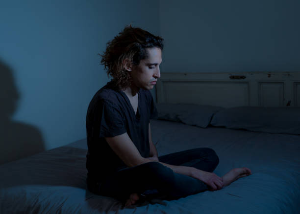 istock Devastated millennial man crying sad feeling hurt and hopeless suffering Depression. Depressed teenager victim of bullying or abuse sitting on bed alone in despair at night. In teenage Mental health. 1175451952