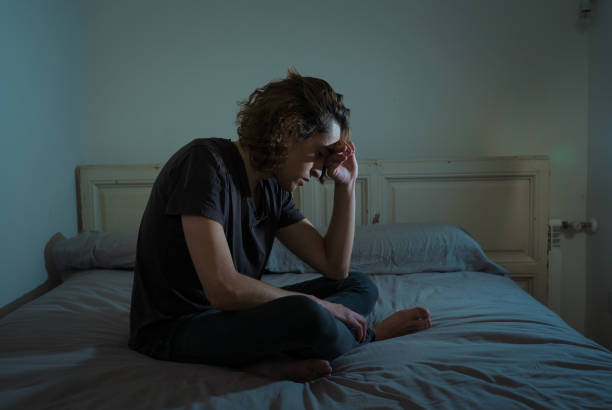 istock Devastated millennial man crying sad feeling hurt and hopeless suffering Depression. Depressed teenager victim of bullying or abuse sitting on bed alone in despair at night. In teenage Mental health. 1175452133
